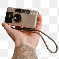 Film camera png sticker, held by tattooed photographer
