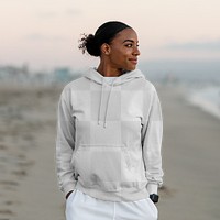 Streetwear apparel mockup png, young woman wearing hoodie at the beach