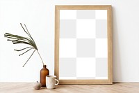 Picture frame mockup on a wooden sideboard table with a dried leaf in a bottle vase