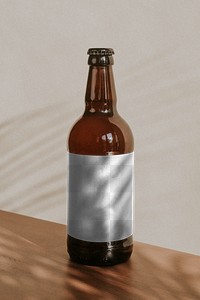 Brown beer bottle on wooden background design element
