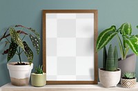 Picture frame png mockup on a shelf with plants against a wall