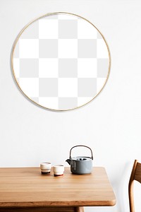 Golden round frame on a white wall by a tea set