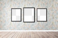 Three blank black picture frame mockups hanging on a floral wallpapered wall