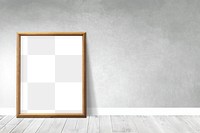 Wooden picture frame mockup leaning against a gray wall