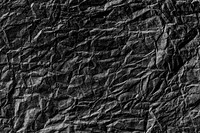 Crumpled black paper textured background design element