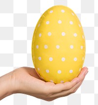 Hand holding a white polka dot patterned yellow egg design element