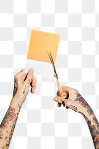 Tattooed hands cutting a yellow paper transparent png