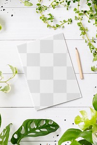 Png paper mockup on wooden table with plants flat lay