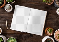 Book png mockup on wooden table with potted plants flat lay