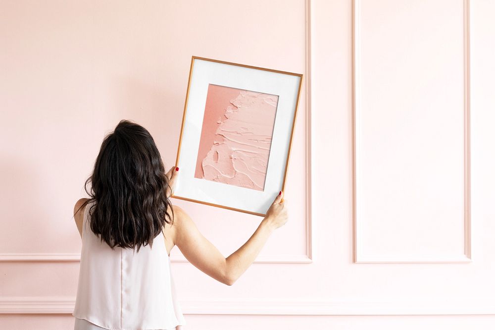 Photo frame mockup, woman decorating wall