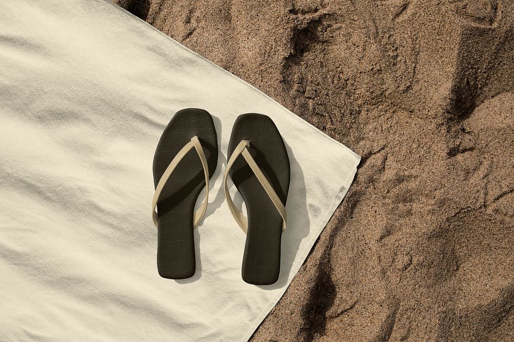 Black flip flop mockups on beach towel aerial view