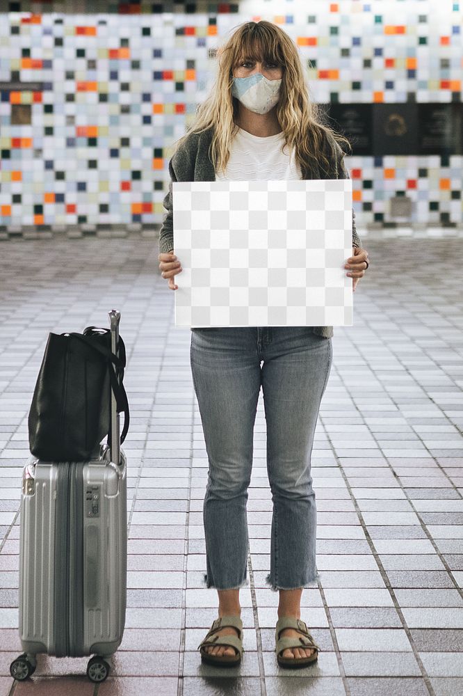 Woman with a suitcase holding a blank paper during the coronavirus outbreak 