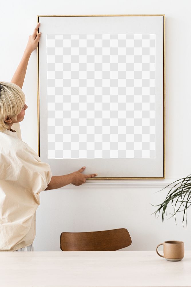 Woman hanging a photo frame on a white wall mockup