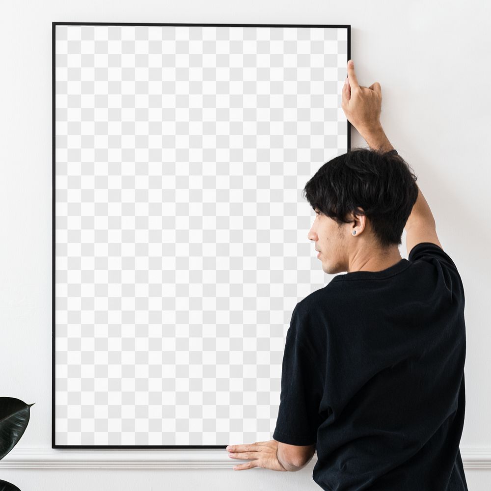 Curator hanging a blank picture frame on a white wall in a gallery