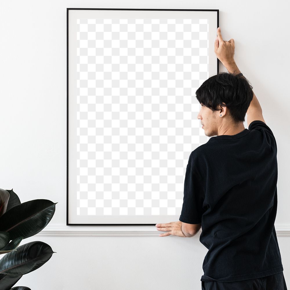 Curator hanging a blank picture frame on a white wall in a gallery