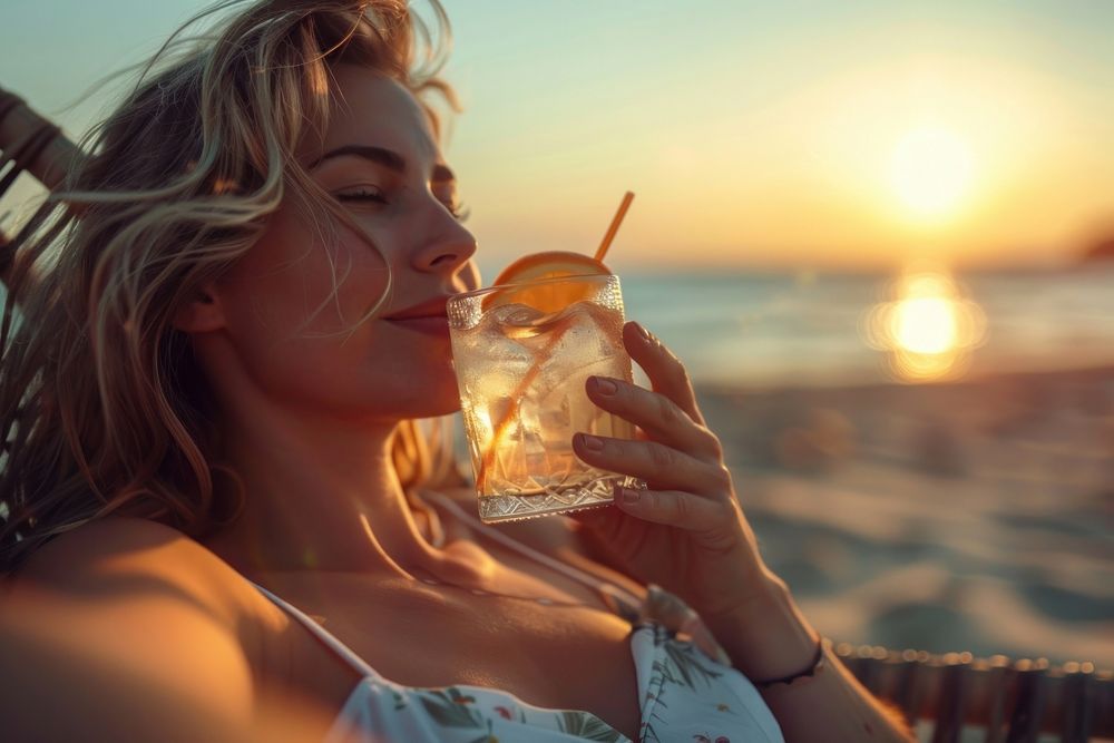 Young woman drinking summer cocktail on the beach bed at sunset beverage alcohol female.