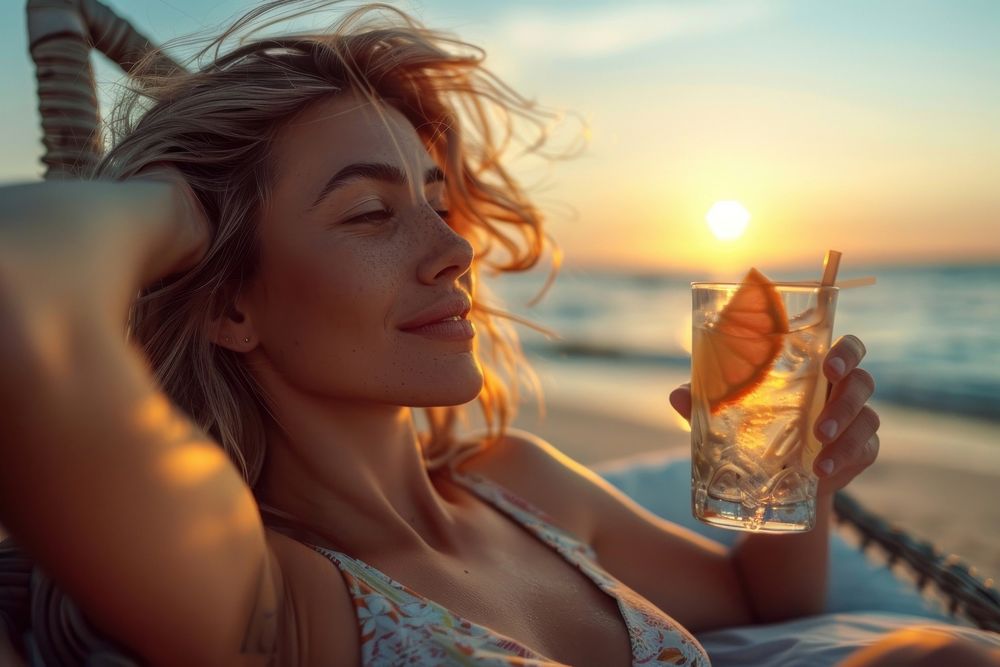 Young woman drinking summer cocktail on the beach bed at sunset photography beverage outdoors.