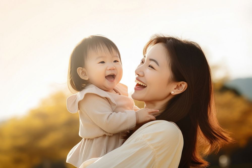 Happy Asian mother plays with daughter happy baby person.