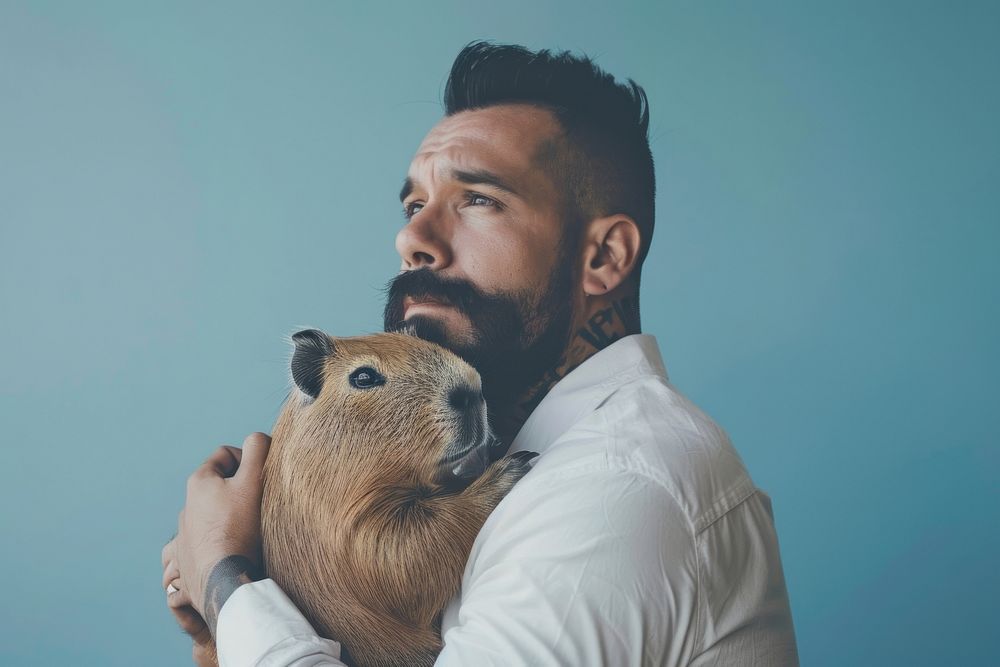 Hispanic man holding capybara portrait photography person.