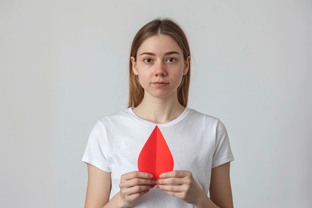 Holding paper red drop shape t-shirt woman surprised.