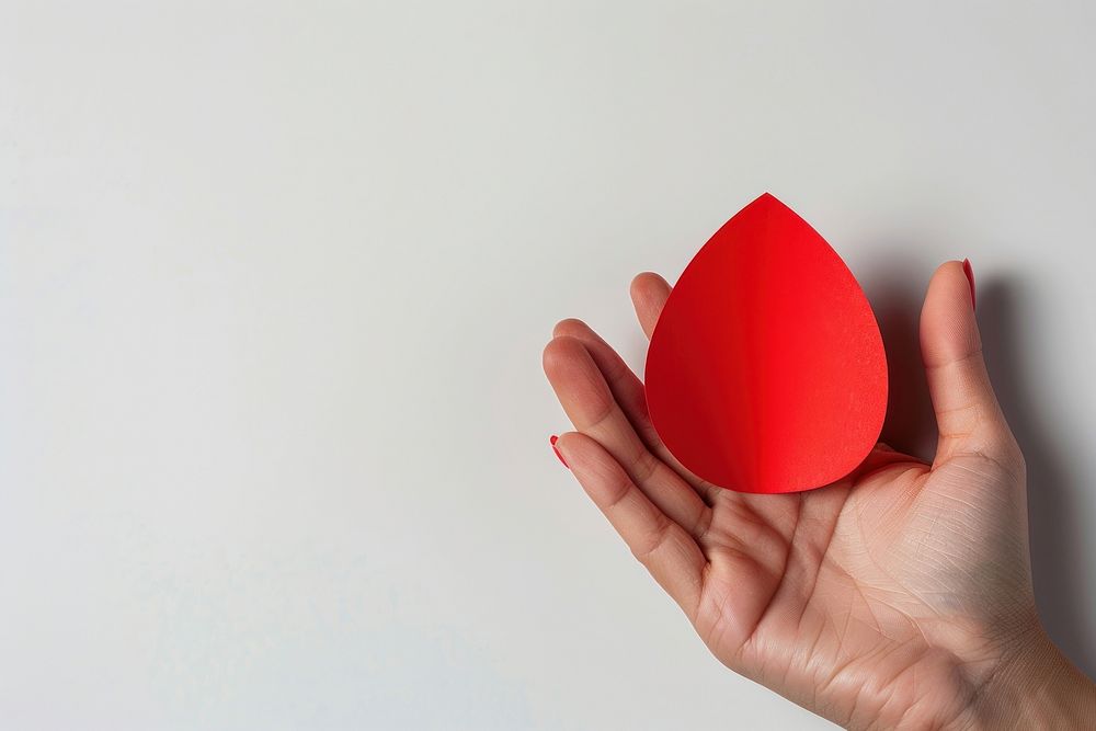 Woman holding red paper cut out of red drop shape symbol racket sports.
