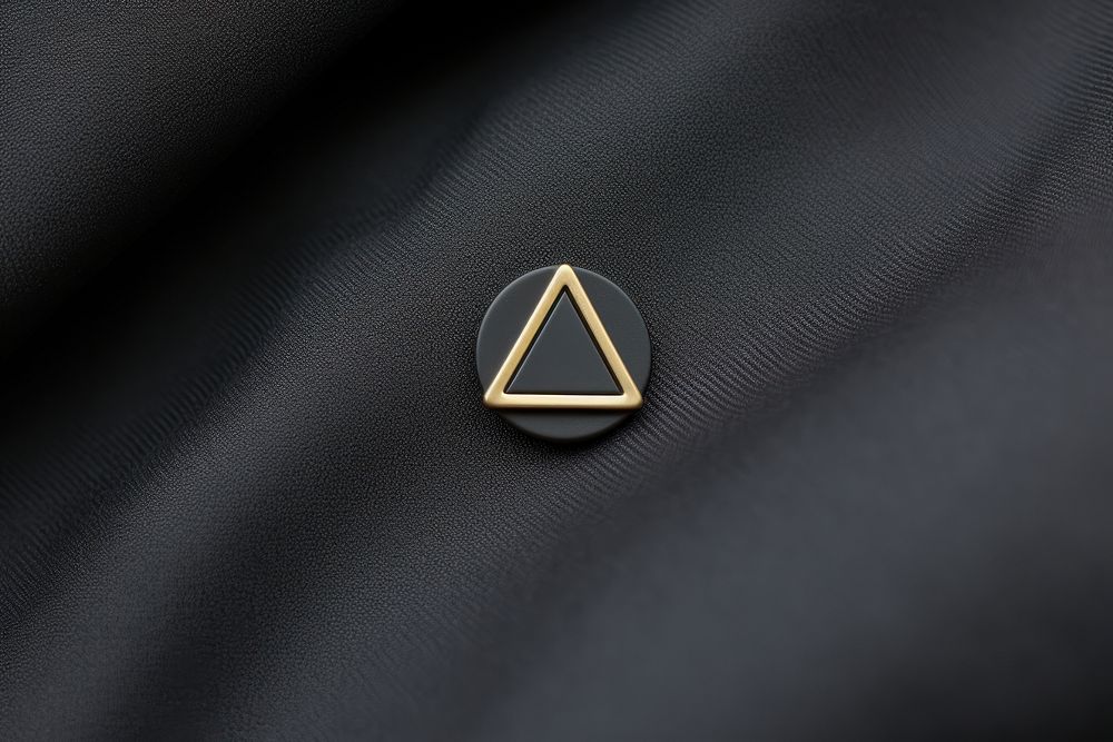 Minimalist lapel pin triangle symbol logo.