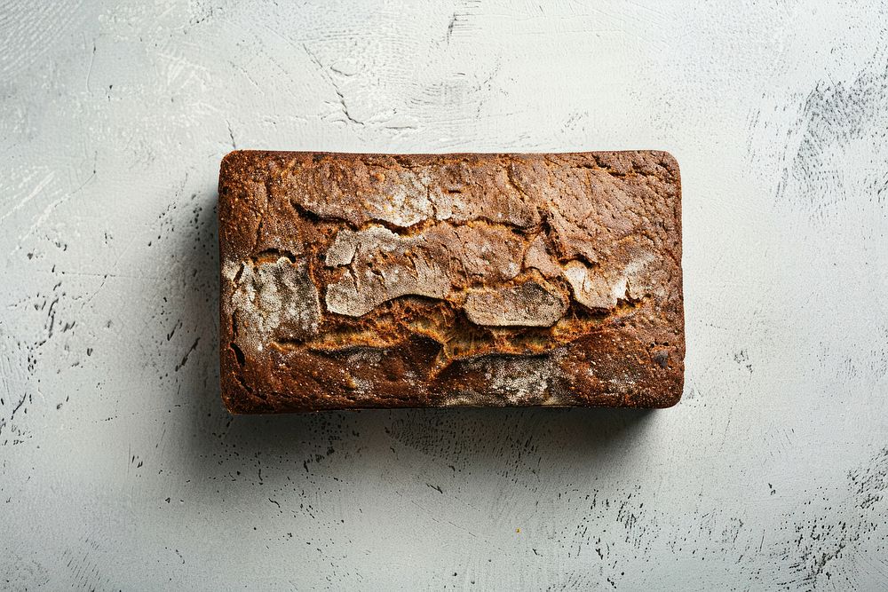 Photo of pumpernickle loaf of bread on light grey top confectionery medication corrosion.