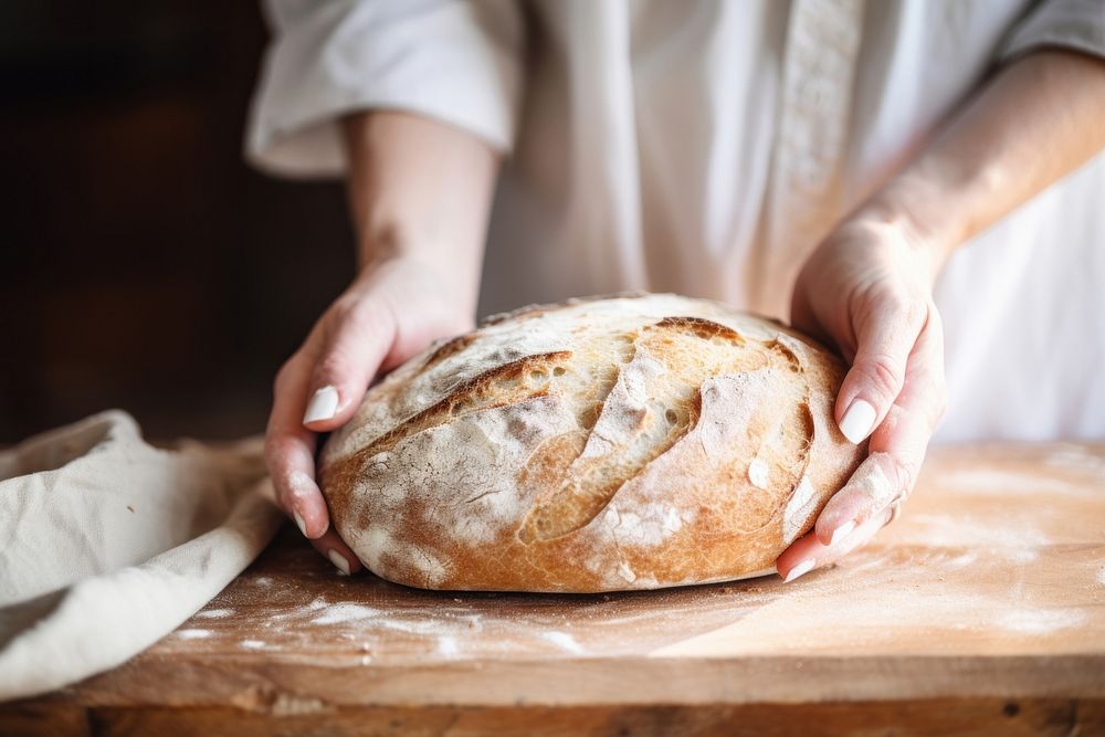 Woman hand on sourdough bread on board cooking food kneading dough.