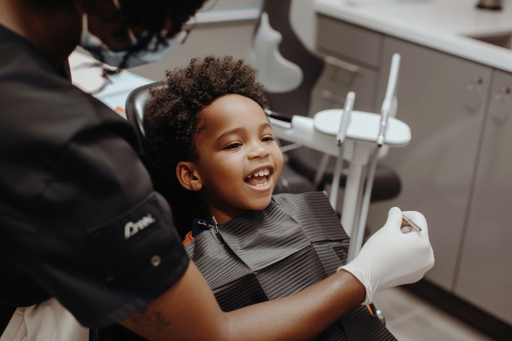 Checking teeth of child sitting on dentist chair hairdresser clothing apparel.