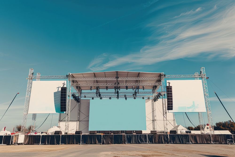 Outdoor concert stage construction with empty white tent and empty billboard outdoors architecture electronics.