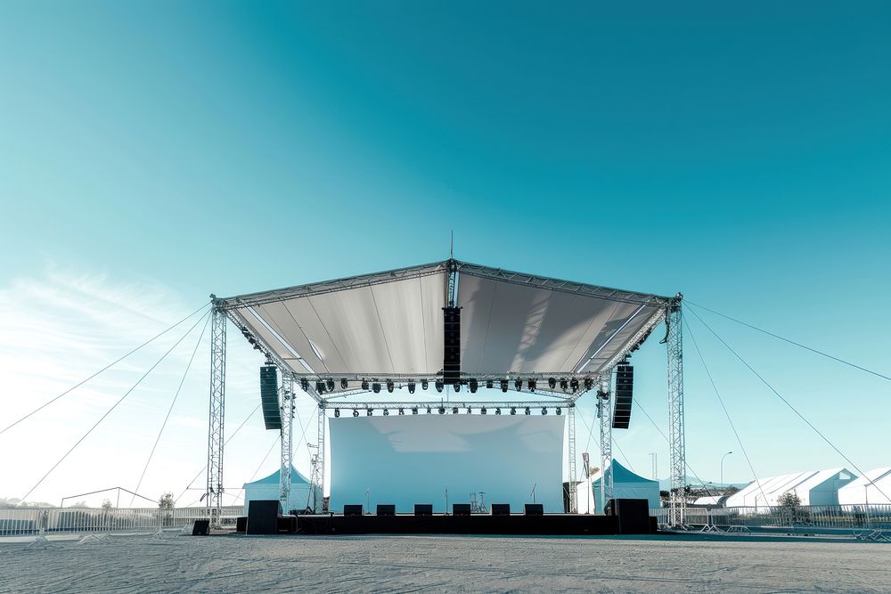 Outdoor concert stage construction with empty white tent and empty billboard outdoors electronics speaker.