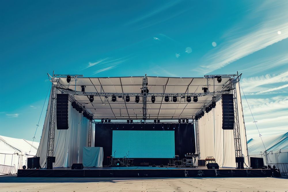 Outdoor concert stage construction with empty white tent and empty sign on roof electronics blackboard speaker.
