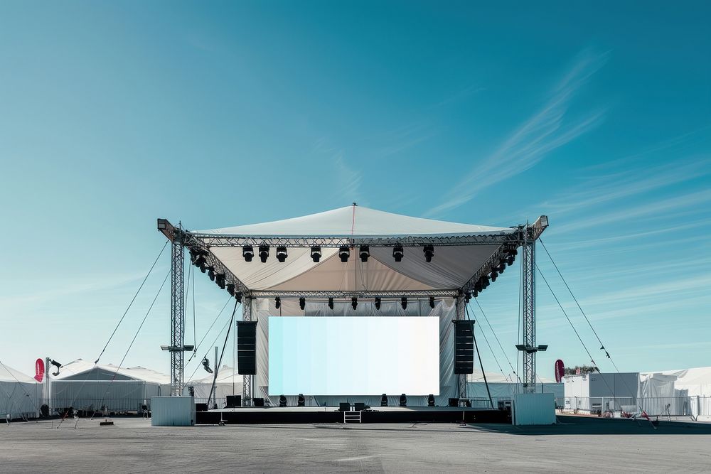 Outdoor concert stage construction with empty white tent and empty billboard outdoors electronics speaker.