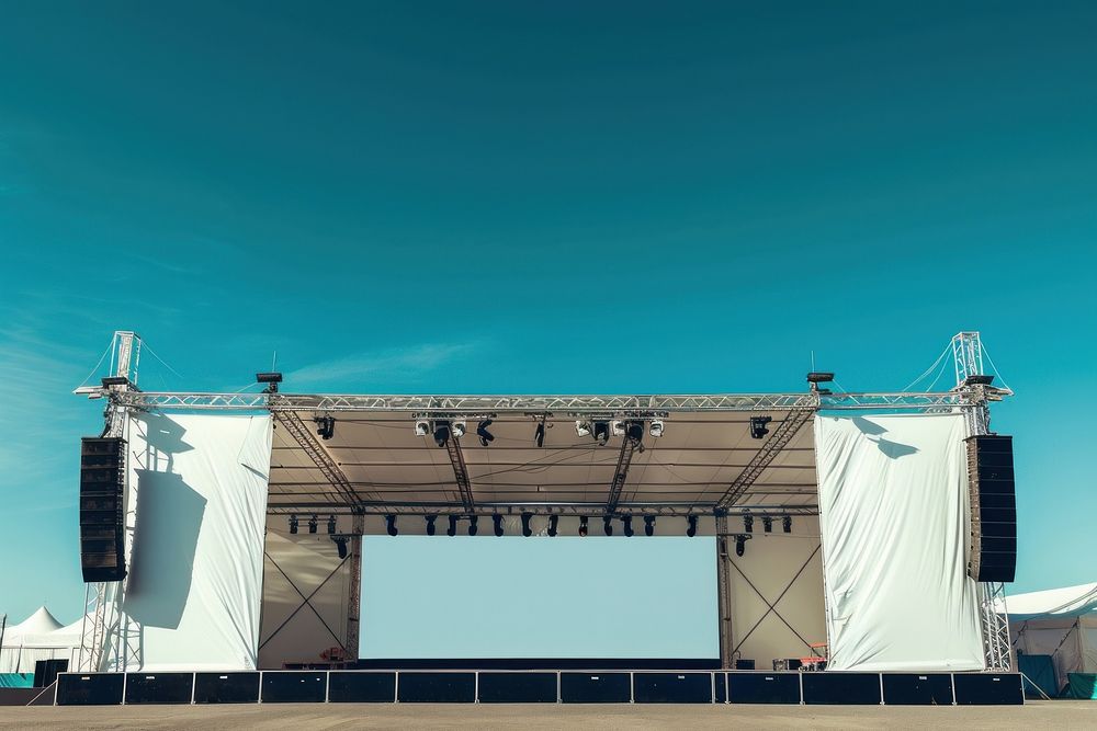 Outdoor concert stage construction with empty white tent and empty sign on roof outdoors architecture electronics.