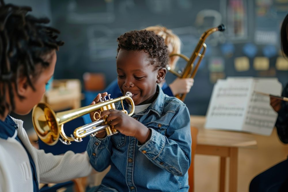Teacher teaching black boy play trumpet at music classroom recreation flugelhorn performer.