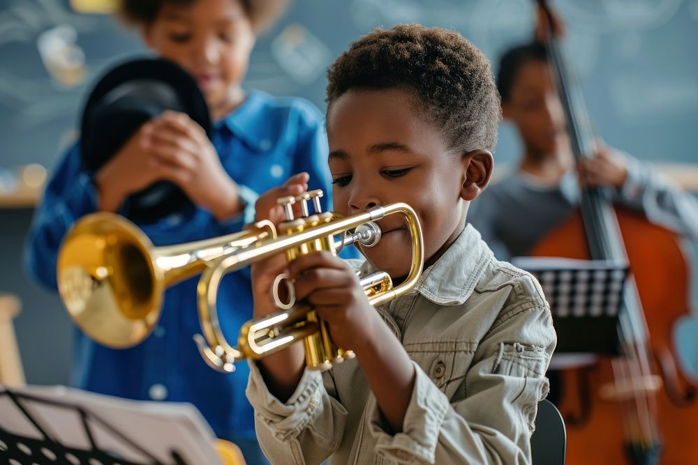 Teacher teaching black boy play trumpet at music classroom recreation flugelhorn performer.