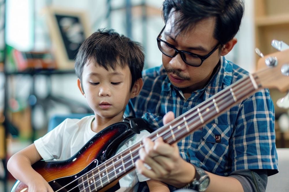 Teacher teaching boy playing bass at music classroom recreation wristwatch guitarist.
