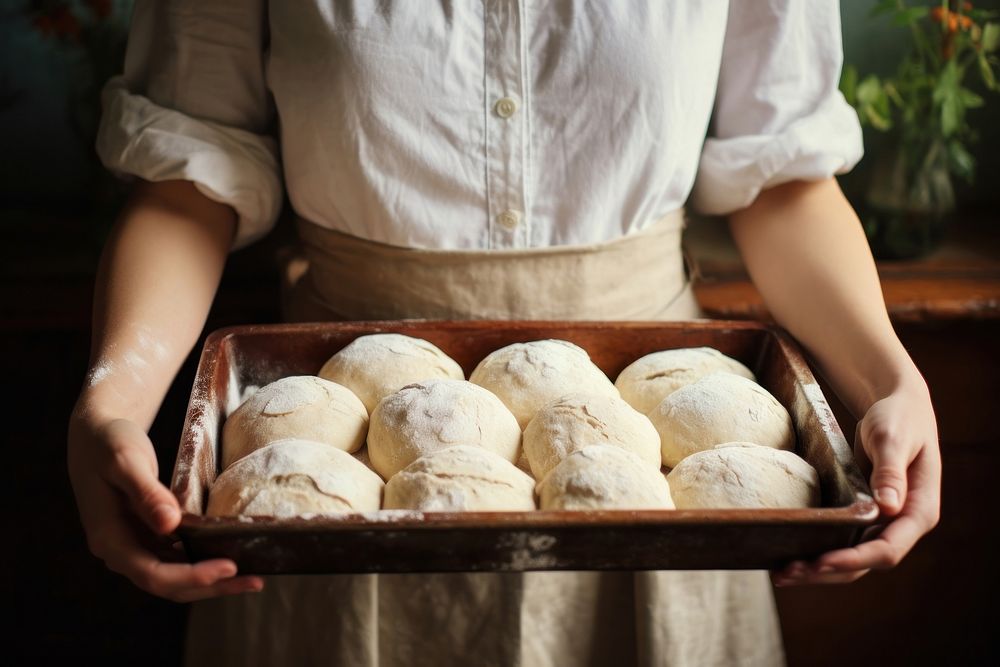 Woman hands hold a baking tray of fresh baked sourdoughs cooking person human.
