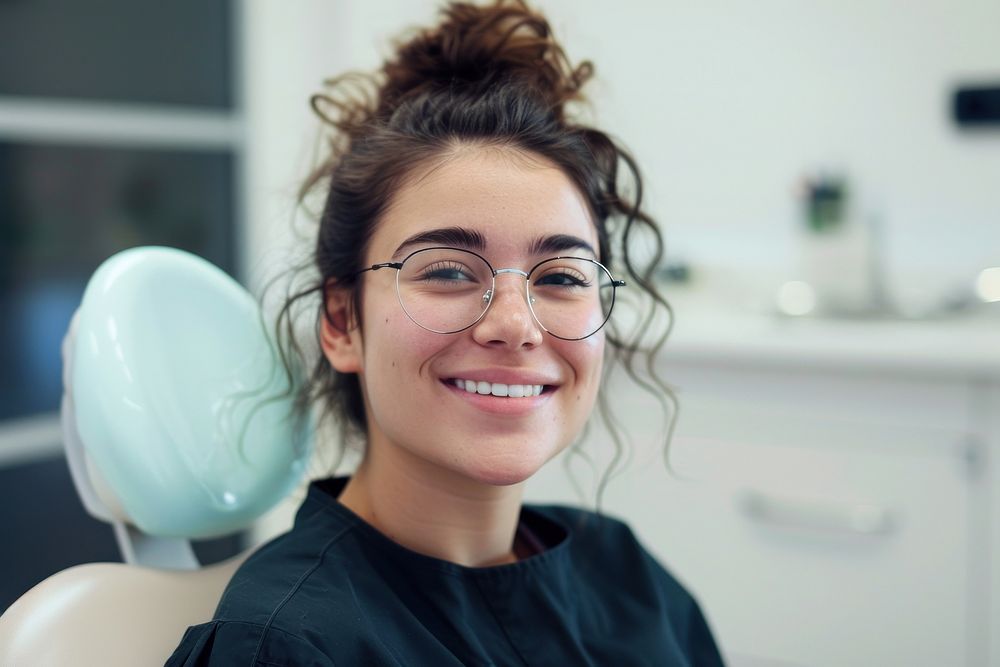 Woman smile with braces sitting on dentist chair accessories accessory glasses.
