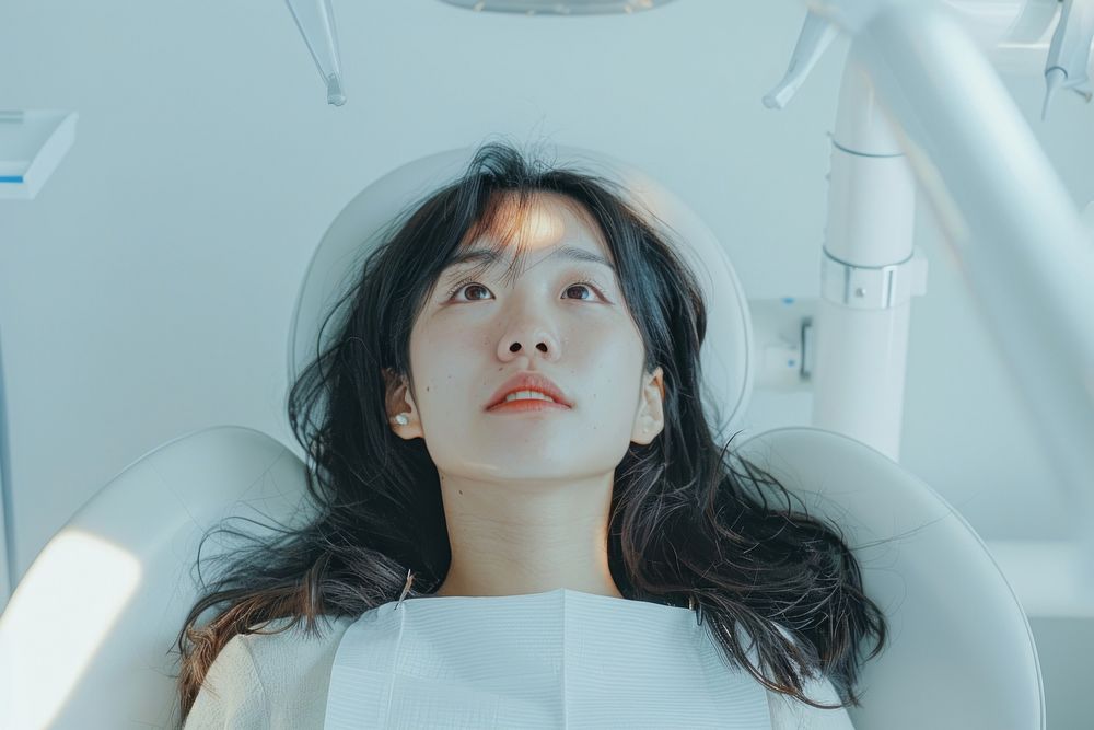 Asian woman mouth open sitting on dentist chair architecture building hospital.
