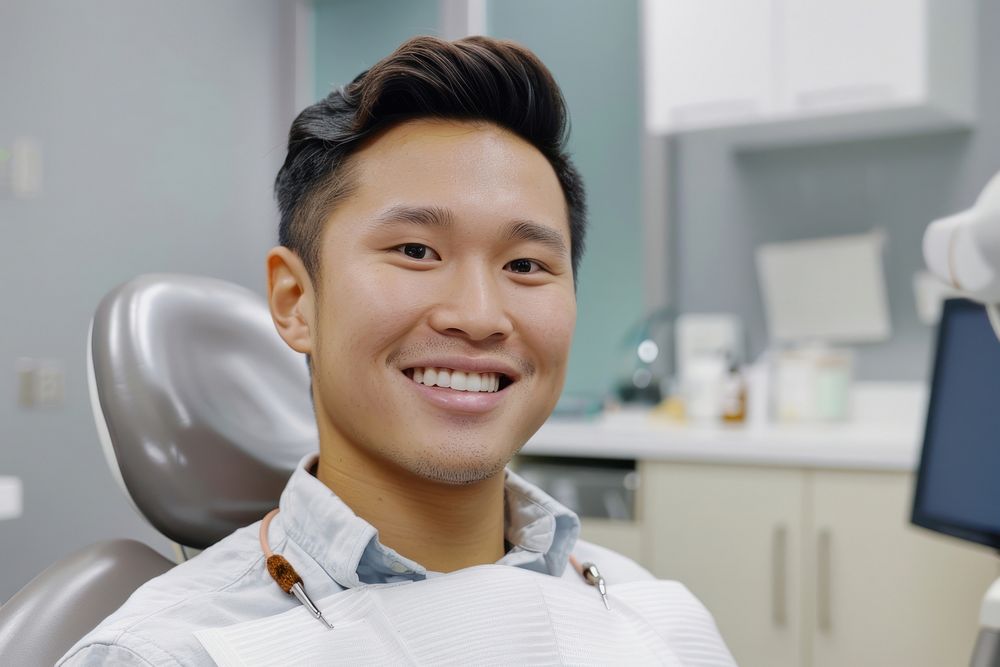 Asian man smile sitting on dentist chair electronics hardware dimples.
