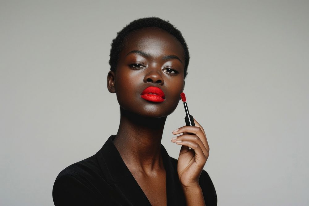 Black holding red lipstick with confident pose photo photography cosmetics.