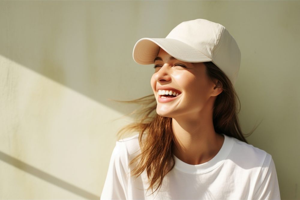 A woman wearing a beige cap happy face clothing.