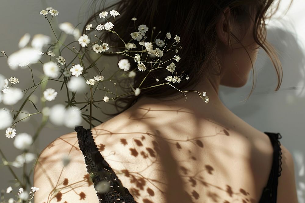 Flower shadow casting on woman back shoulder blossom person.