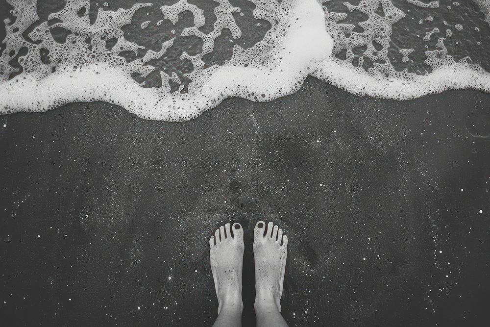 Feet standing on sand beach sea blackboard.