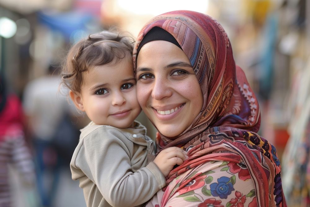 Middle-aged arab woman in hijab carrying little girl photo photography portrait.