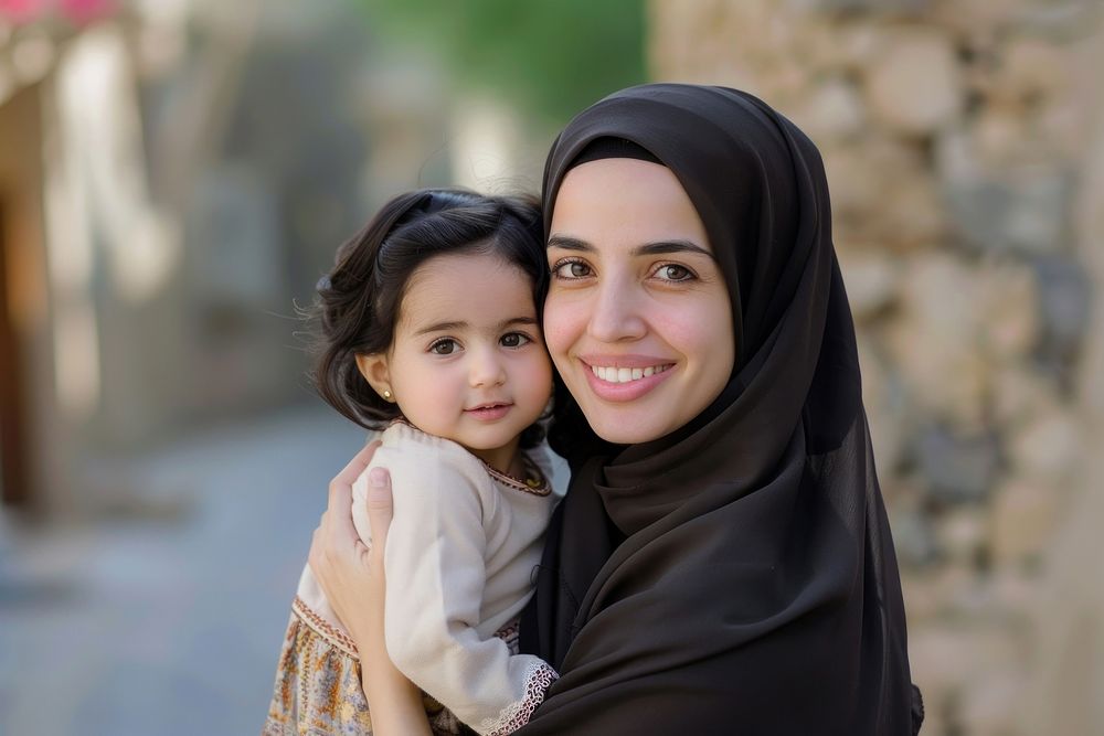 Middle-aged arab woman in hijab carrying little girl photo photography clothing.