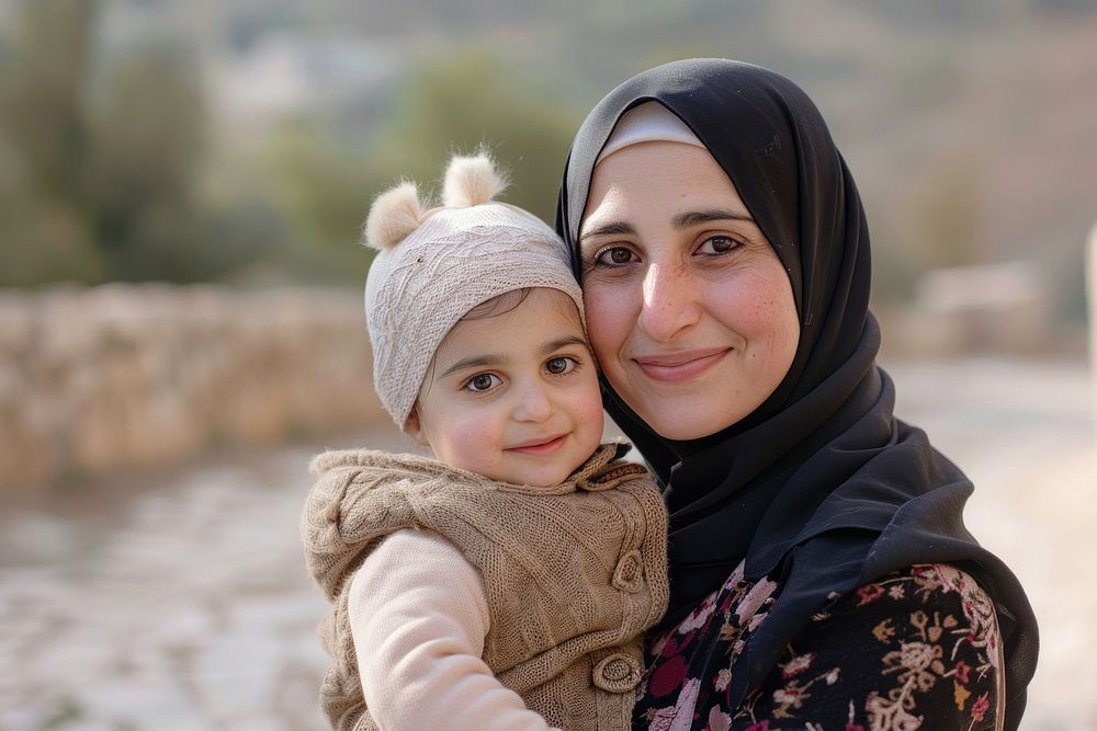 Middle-aged arab woman in hijab carrying little girl photo photography portrait.