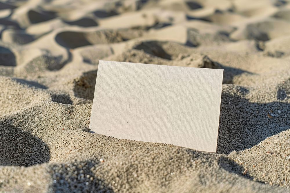 Business card mockup paper sand outdoors.