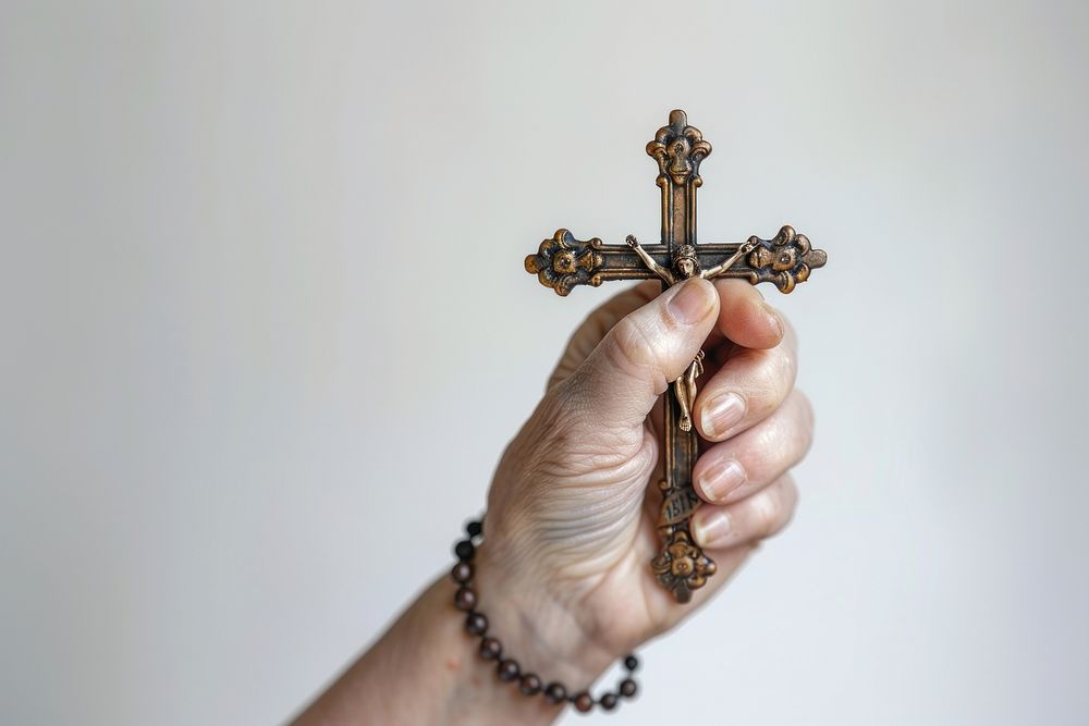 Hand holding cross or crucifix pray worship symbol prayer.